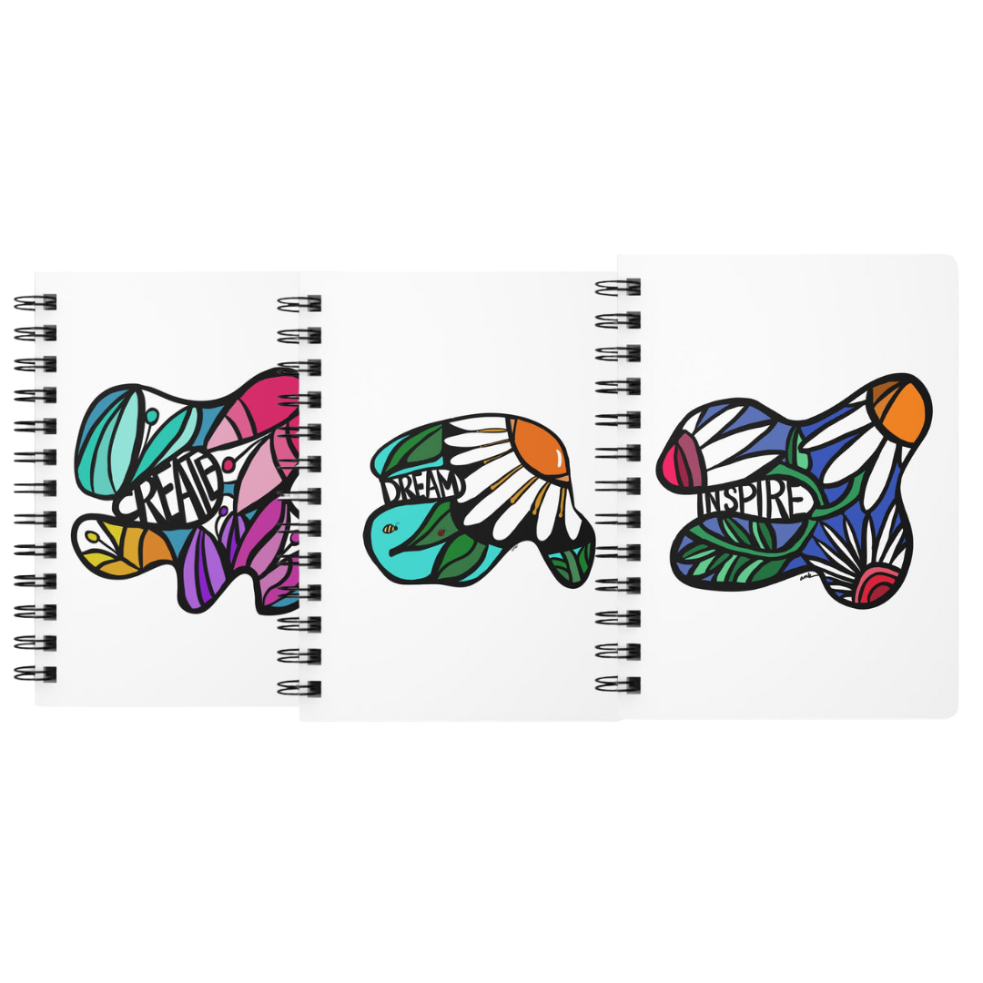 Three colorful spiral journals with abstract flowers and the words 'create, dream, and inspire' by Annmarie Boyle for the Flourish stationery line on annmarieboyle.com