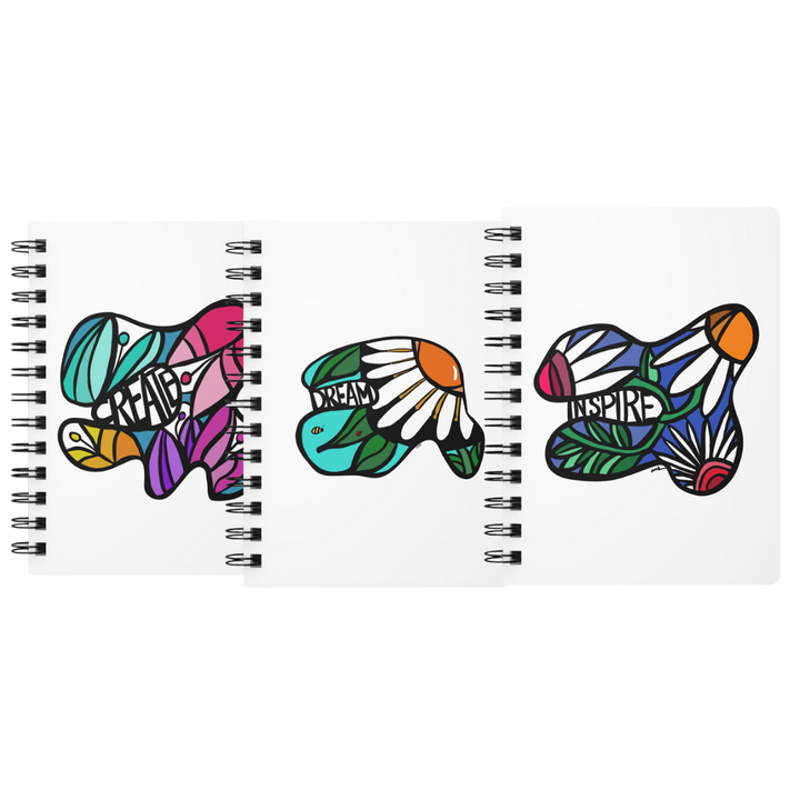 Three colorful spiral journals with abstract flowers and the words 'create, dream, and inspire' by Annmarie Boyle for the Flourish stationery line on annmarieboyle.com